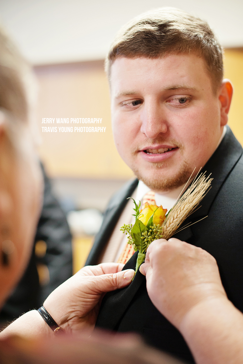 The groom getting his boutonniere pinned