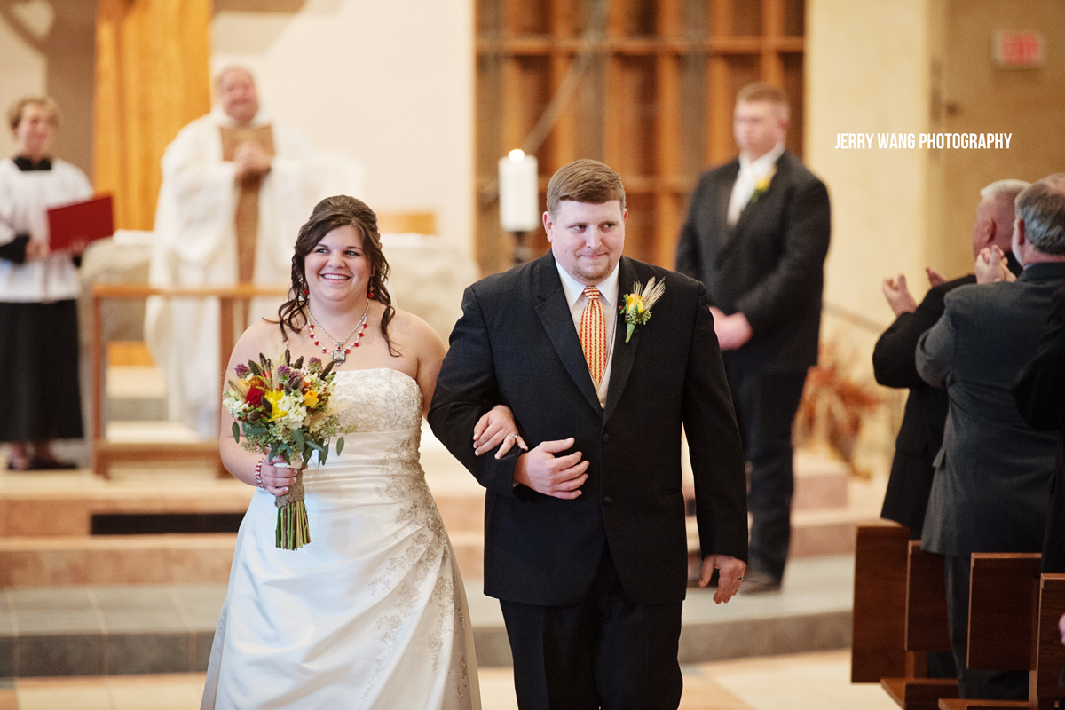 The bride and groom walking down the aisle as a married couple